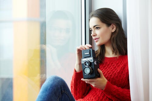 Vrouw Die Rood Gebreid Overhemd Draagt Met Onmiddellijke Camera