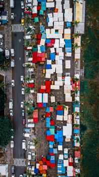 Top view bright roofs of various typical buildings located near road with cars on street in industrial district of town