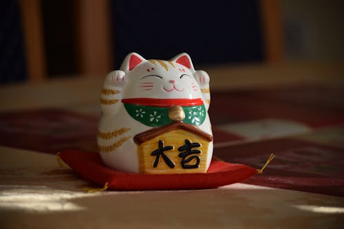Free Maneki-Neko Figurine on Red Pillow Stock Photo