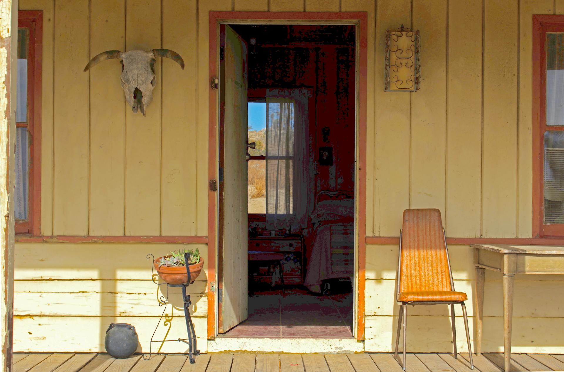 Inviting rustic ranch porch with an open door in Lancaster, California, USA.