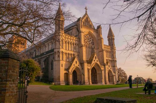 Free The historic St Albans Cathedral lit by the warm glow of a sunset in England. Stock Photo