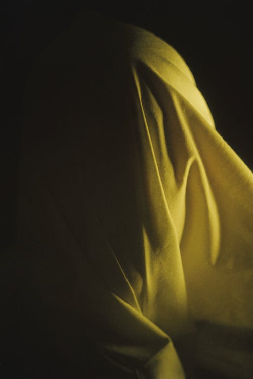 Yellow Fabric Thrown Over a Persons Head 