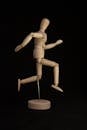 Brown Wooden Mannequin Against Black Background