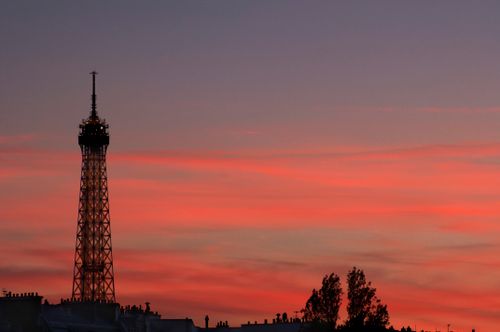 Free Silhouette of the Eiffel Tower against a vibrant sunset in Paris, France. Stock Photo