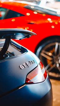 Elegant GT 63 close-up with a blurred red sports car background. Perfect for automotive enthusiasts.