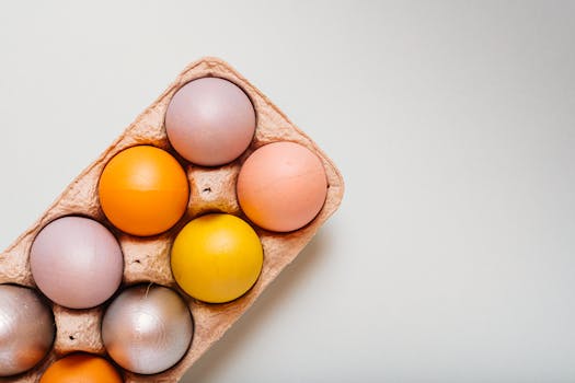 A collection of colorful pastel Easter eggs arranged in a cardboard egg tray, perfect for spring decoration.