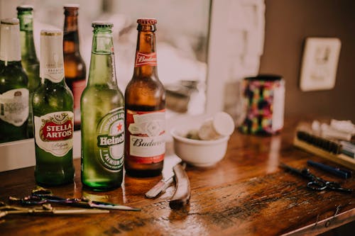 Ücretsiz Kahverengi Ahşap Masa üzerinde üç çeşitli Içecek şişeleri Stok Fotoğraflar