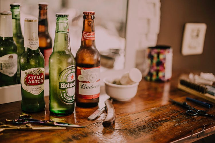 Three Assorted Beverage Bottles On Brown Wooden Table