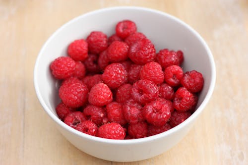Selective Focus Photography of Raspberries in White Ceramic Bowl