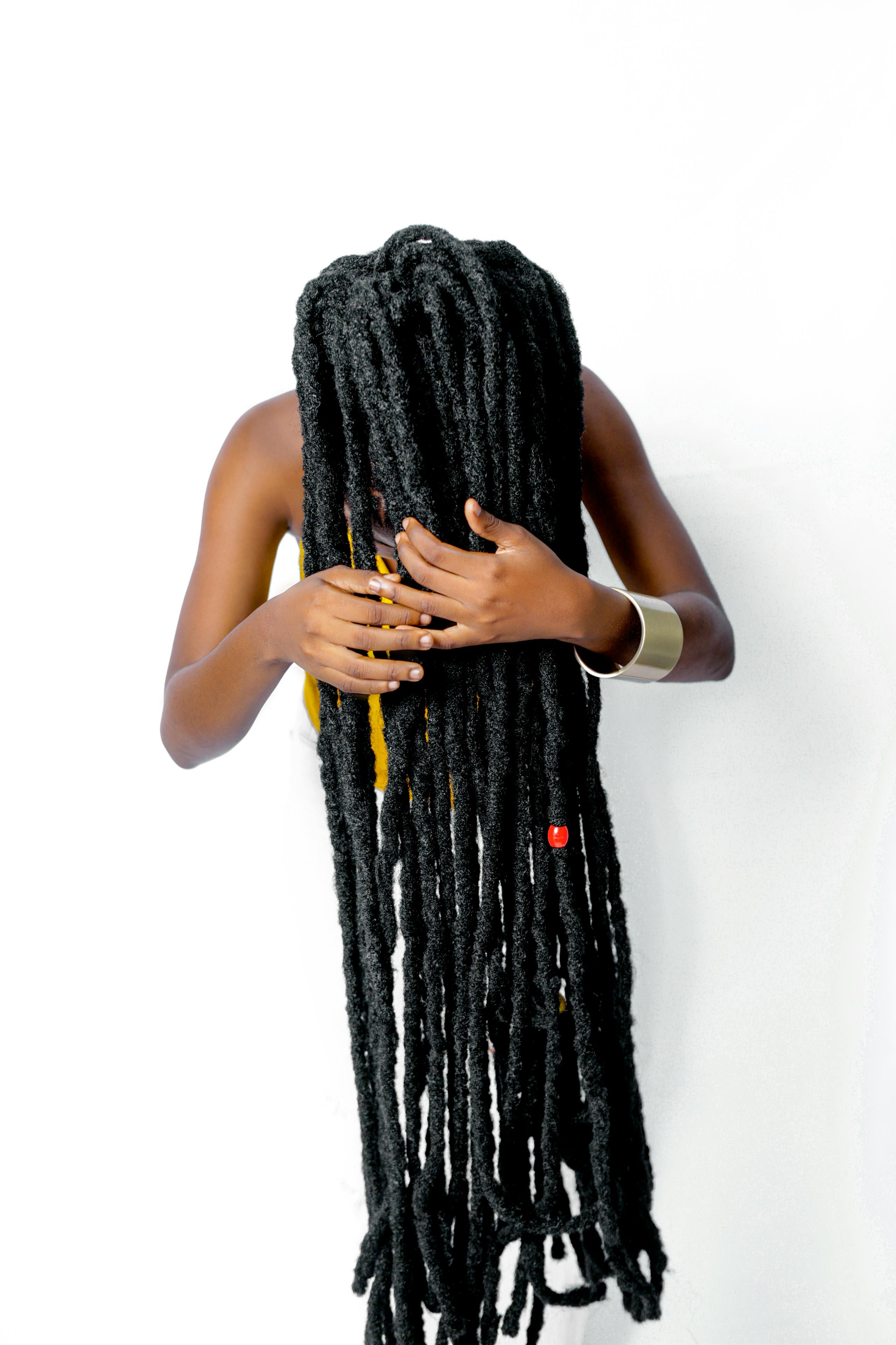Foto profissional gratuita de cabelo comprido, dreadlocks, fundo branco, mãos, tiro de estúdio, tiro vertical