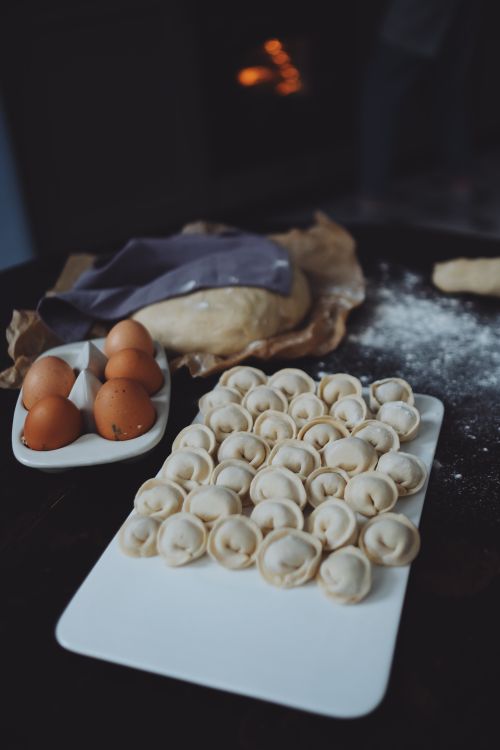 Free A cozy setup of homemade dumplings ready for cooking with dough and eggs on a table. Stock Photo