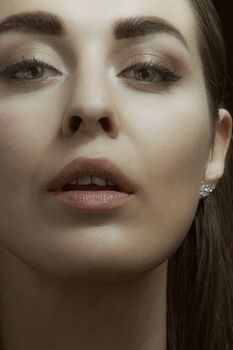 Close-up portrait of a woman with makeup, highlighting facial features and elegance.
