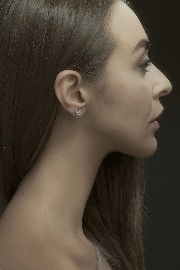 A Side View Of A Woman Wearing A Diamond Earring