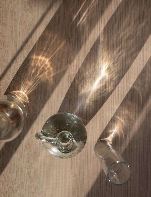 Assorted glassware on shiny table with shadows