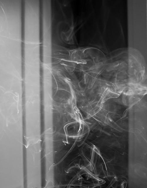 Cigarette smoke floating in dark room