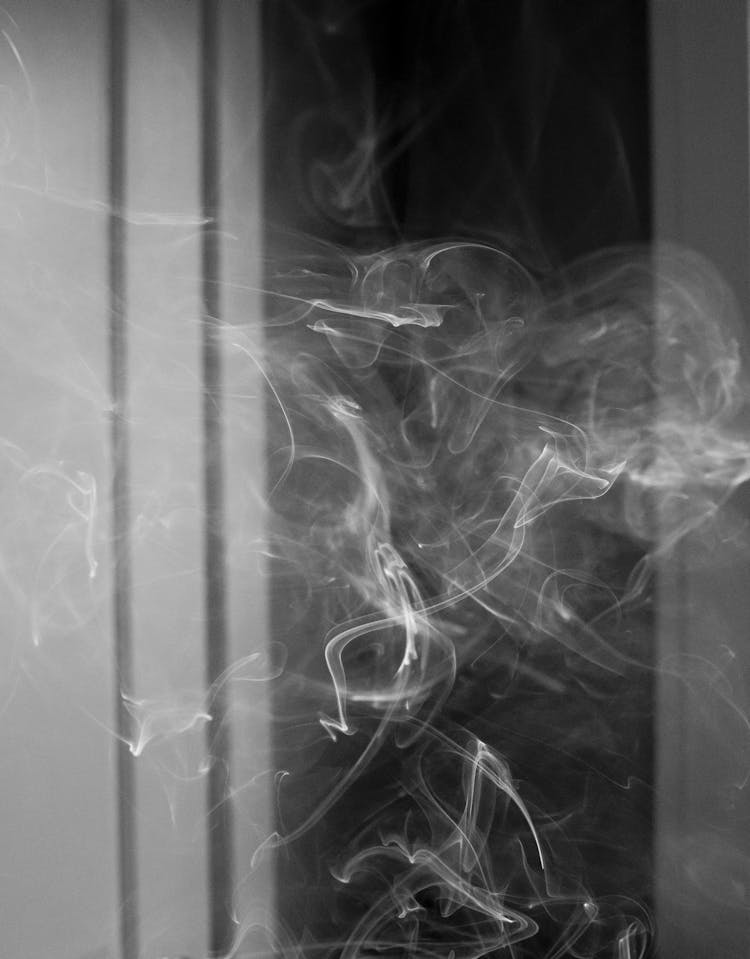 Cigarette Smoke Floating In Dark Room