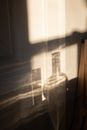 Wall with gentle shadows of glass flasks of different shape in sunlight in daytime