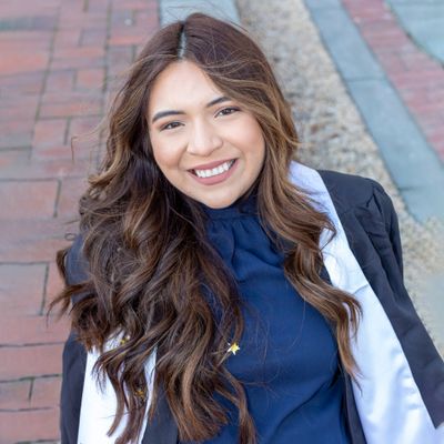 Graduate smiling in cap and gown — photo by Jeff Denlea on Pexels