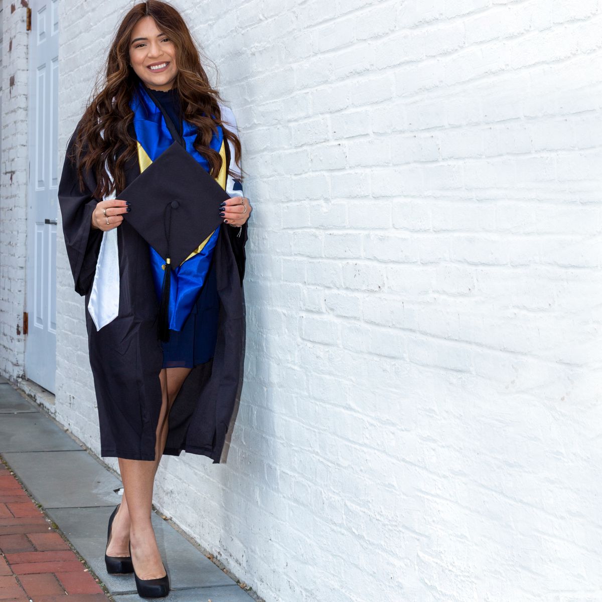 Happy woman in graduation outfit smiling with diploma — personalized gift ideas