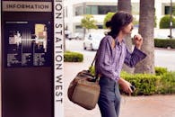 在洛杉矶联合车站，时尚的年轻人拎着包等候，体现了城市探索