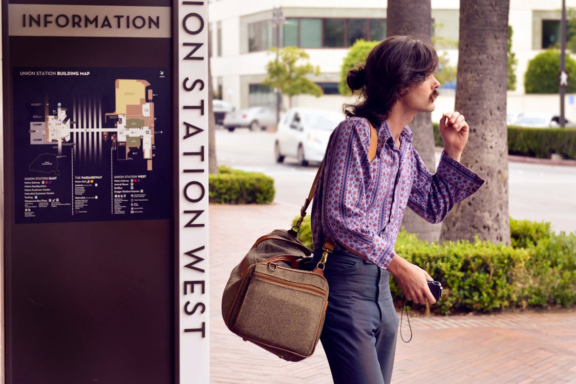 Person Wearing Purple Dress Shirt and Black Pants White Carrying Brown Sling Bag