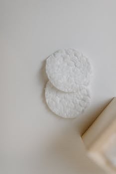 Two cotton pads on a white background with minimalistic design layout.