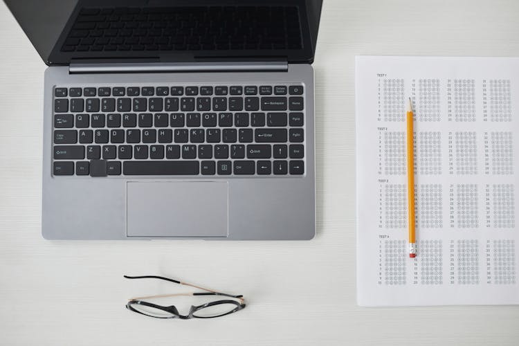 A Top View Of Laptop And Test Paper On The Table