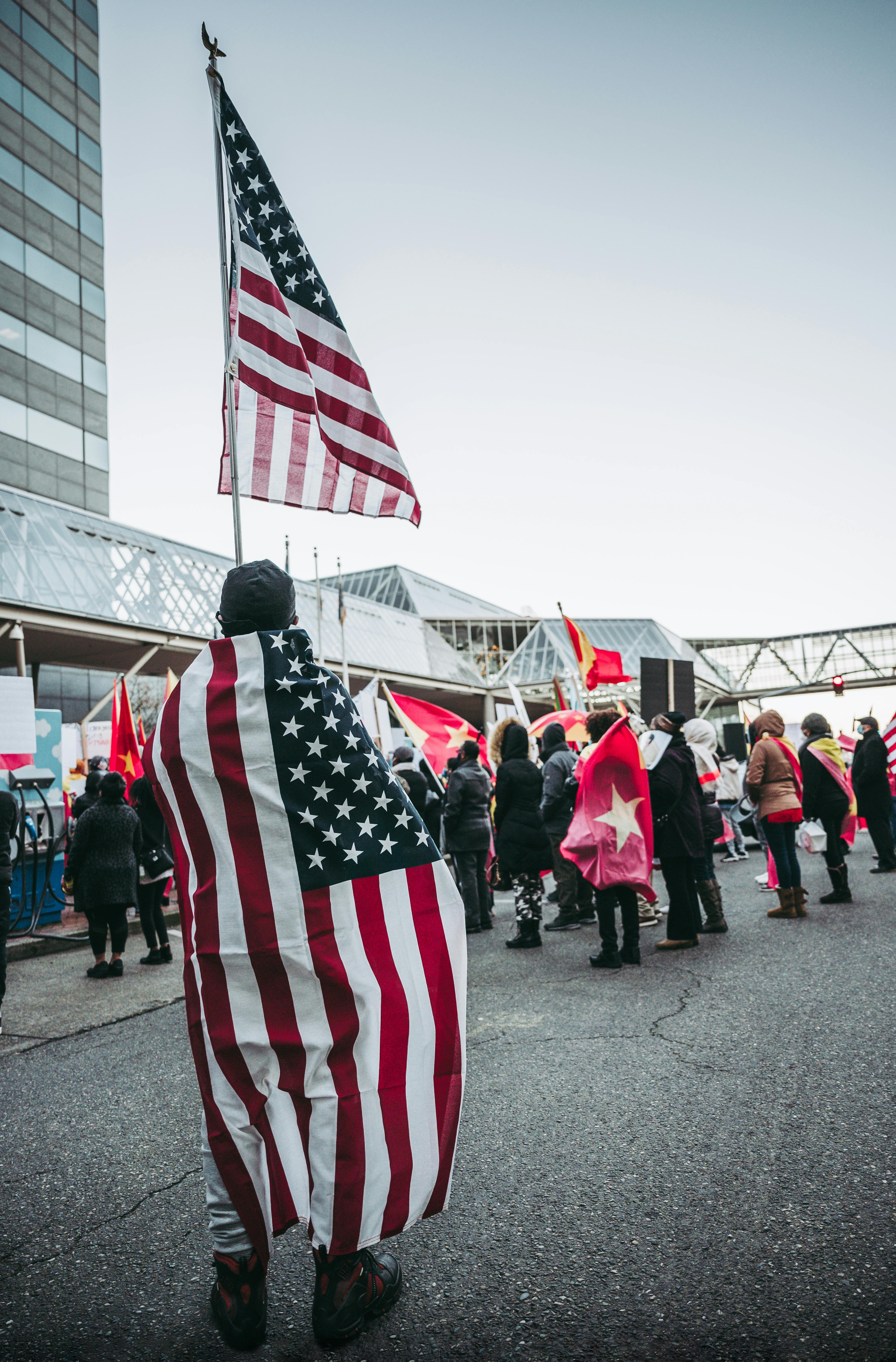 unrecognizable patriotic people with us flags standing on street during parade