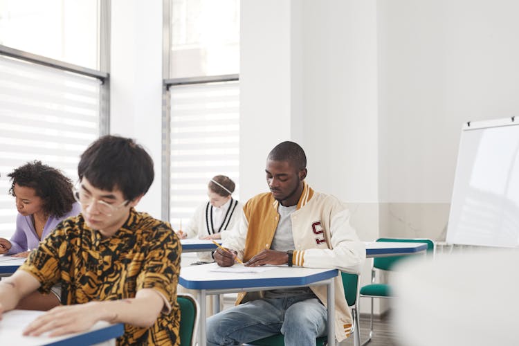 Students Sitting Inside The Classroom While Taking Exam