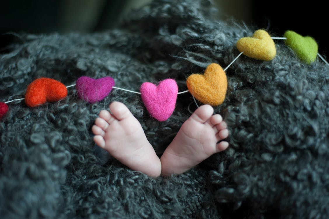 Baby's Feet Covered With Black Wool Textile