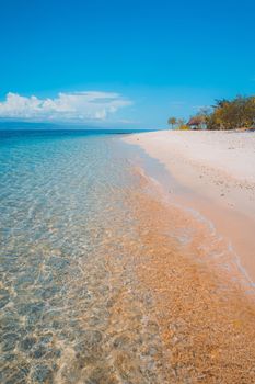 Scenic view of a tropical beach with clear turquoise waters and white sand under a bright blue sky. - Fotografer Sidoarjo