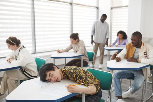 Students in a classroom taking an exam, showcasing diversity and focus.