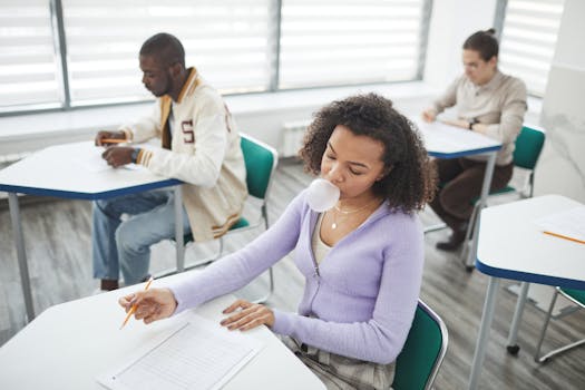 Group of students taking a test in a bright, modern classroom with focus on diversity and education.