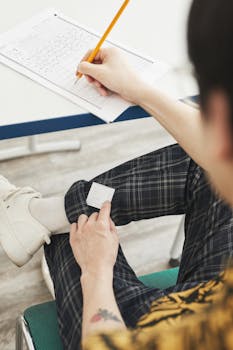A student discreetly using a cheat sheet hidden on their lap during an exam.