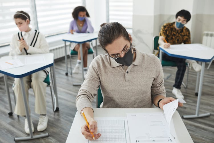 A Man Wearing Face Mask While Taking Exam