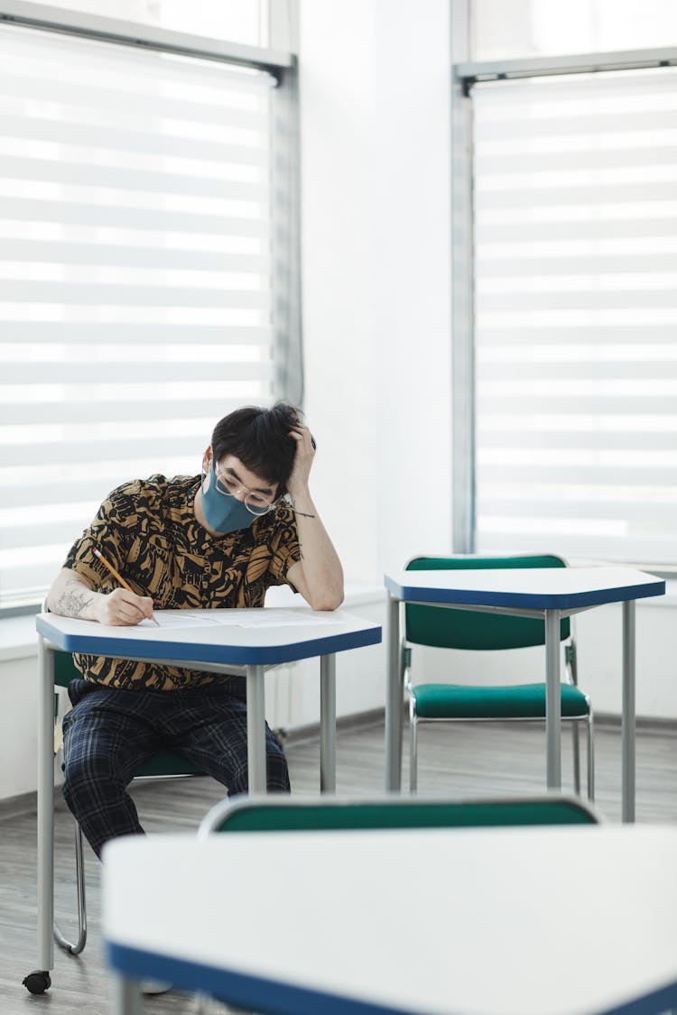 A Man Taking Exam While Wearing Face Mask