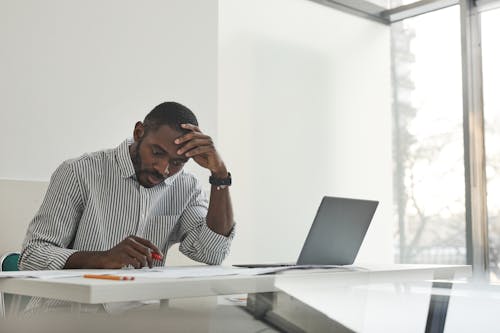 Free A Man Sitting while Working Stock Photo
