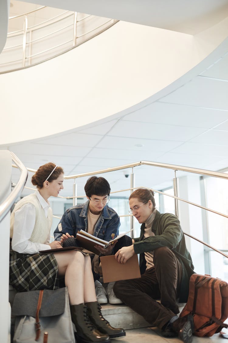 Students Sitting On The Stairs While Studying