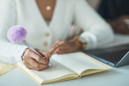 Free A Woman Writing on a Notebook Stock Photo