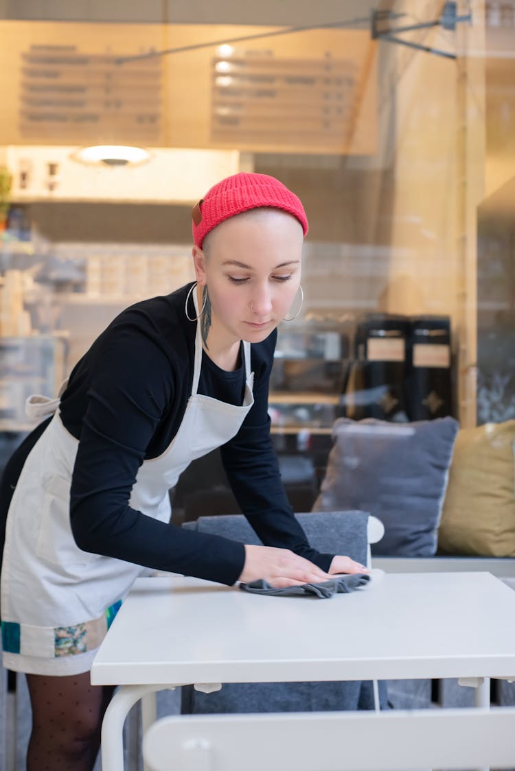 A Coffee Shop Employee Cleaning The Table