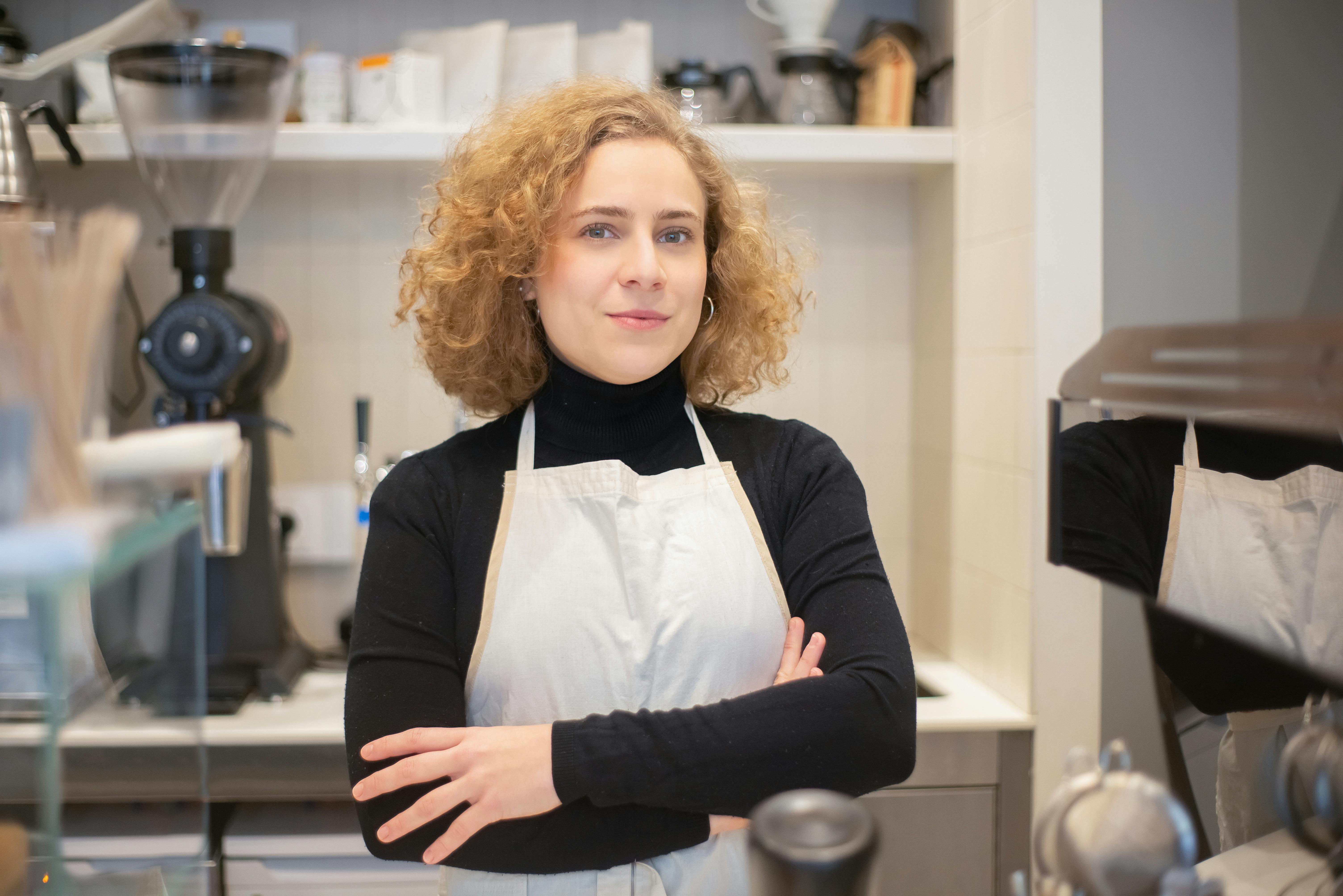 a woman wearing apron working in a coffee shop