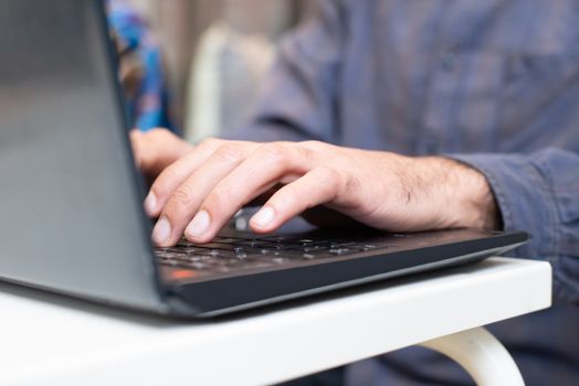 Close-up of hands typing on a laptop keyboard, focused and professional setting.