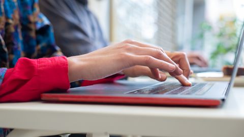 Person typing on a laptop indoors in Portugal, showing productivity and technology use.