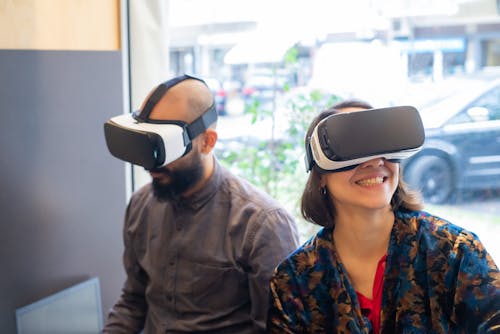 Free Man and Woman Using Virtual Reality Headsets Stock Photo