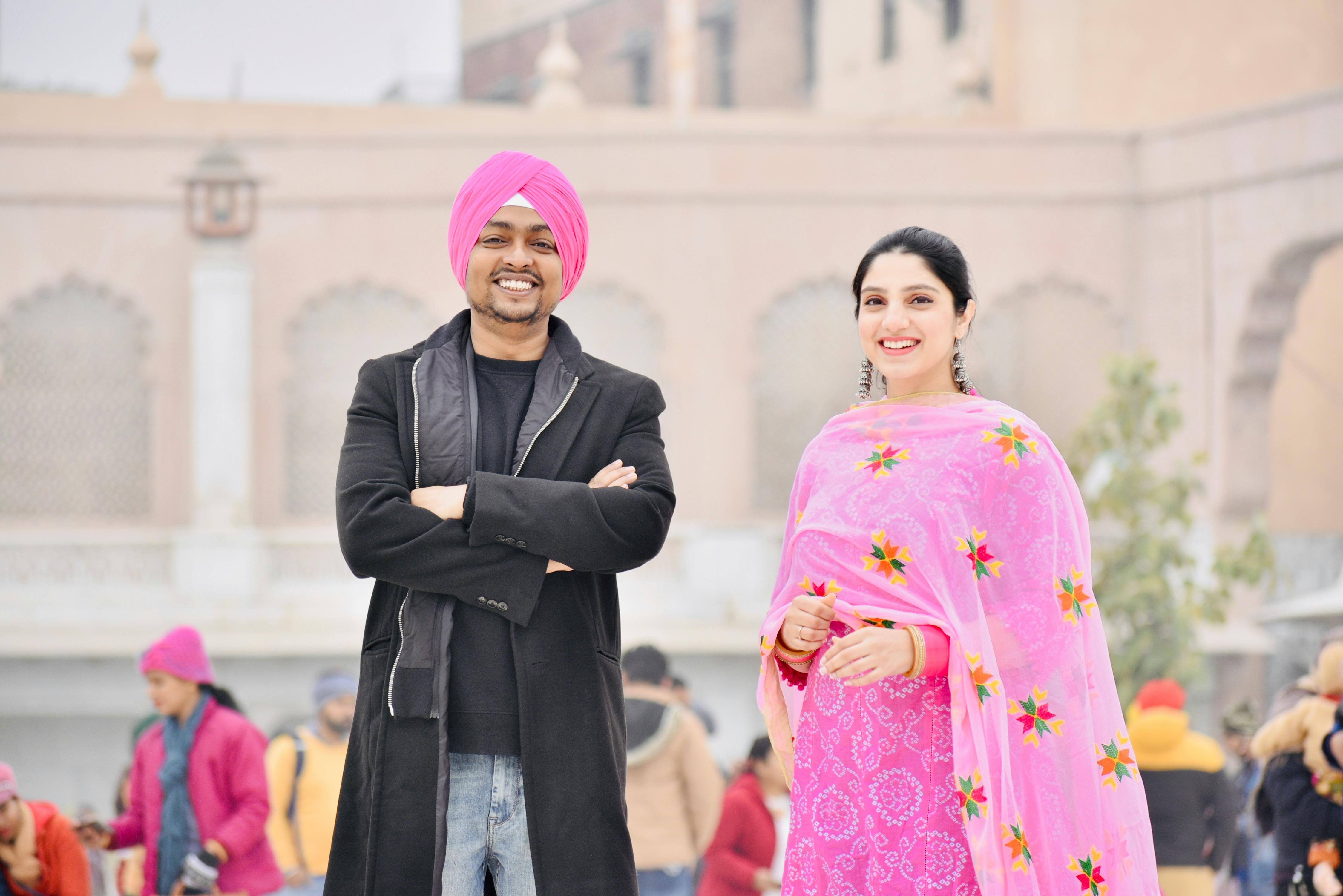 Smiling Indian couple wearing traditional clothes outdoors, exuding joy and cultural pride.