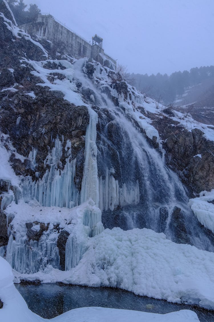 Frozen Stream Of Water On Rocky Slope