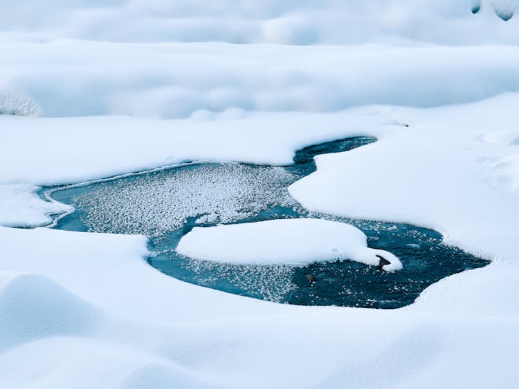 Frozen Pond Under Snow In Wintertime