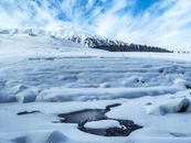 Snowy terrain near frozen lake