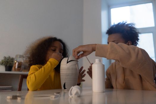 Two children fixing a vase at home, showcasing teamwork and creativity.