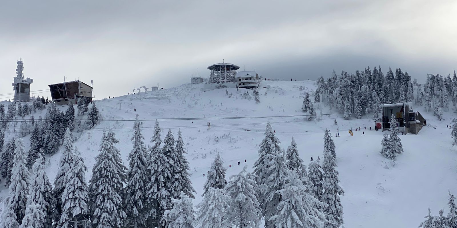 Snowy mountain resort with frosty trees and ski lifts